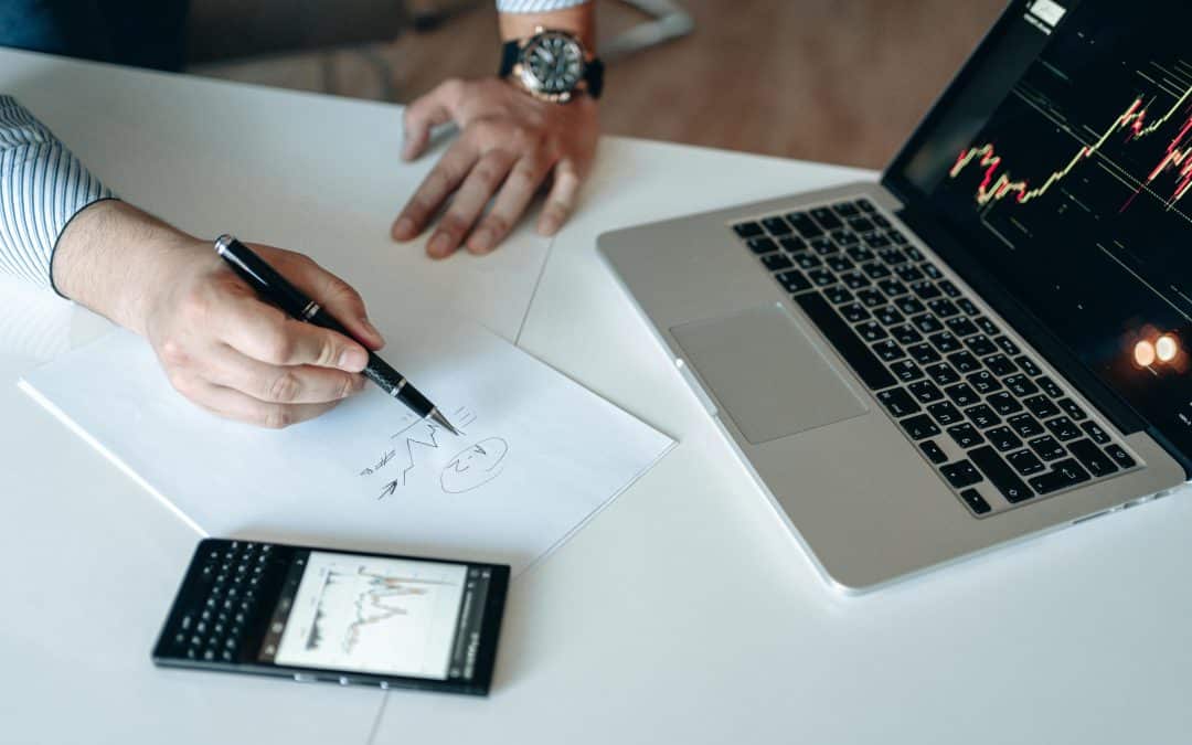 Business man's hand writing with stock growth on his screens